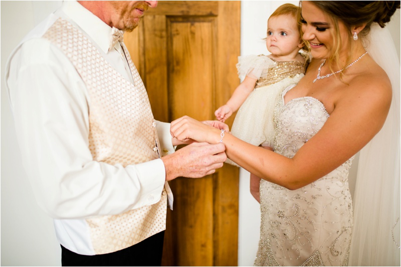 Father of the bride helps his daughter put on her final jewelry for her wedding day