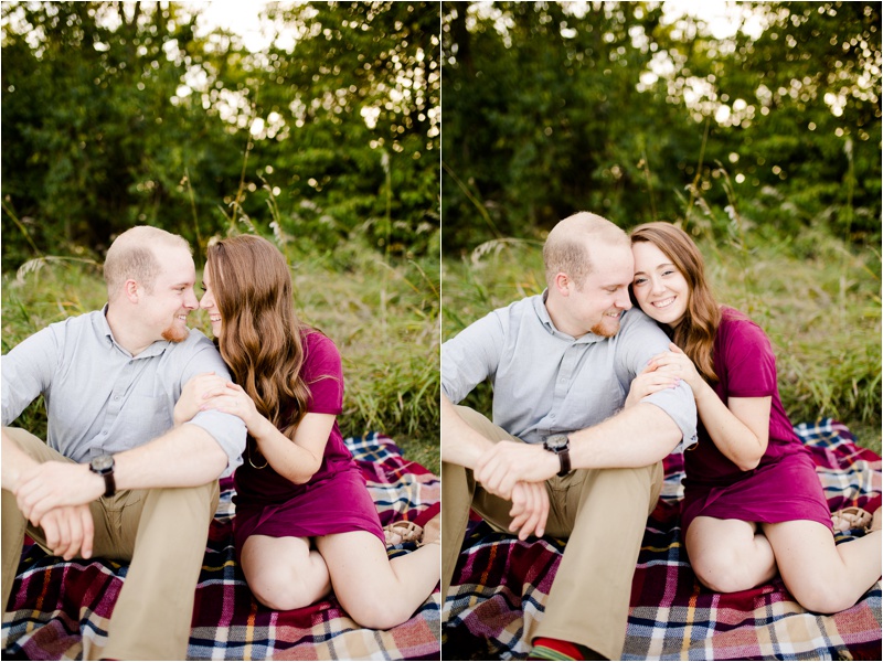 Couple sits on plaid blanket for their fall engagement session