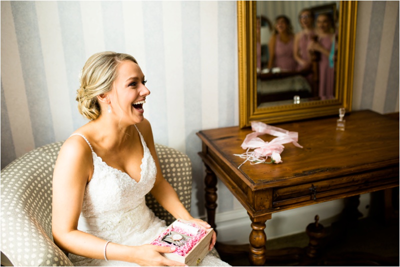 bride is laughing at what the bridesmaids are saying outside of the picture