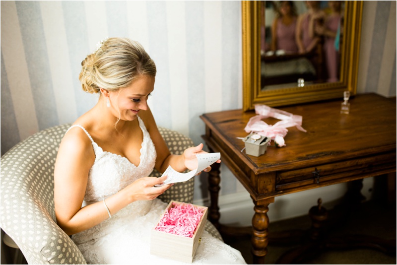 The bride is smiling as she reads a letter from her groom