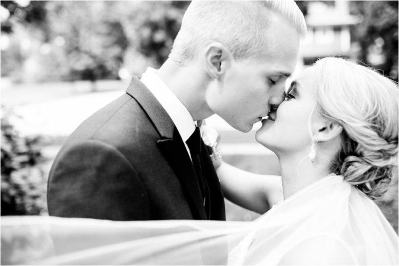 Black and white image of bride and groom kissing