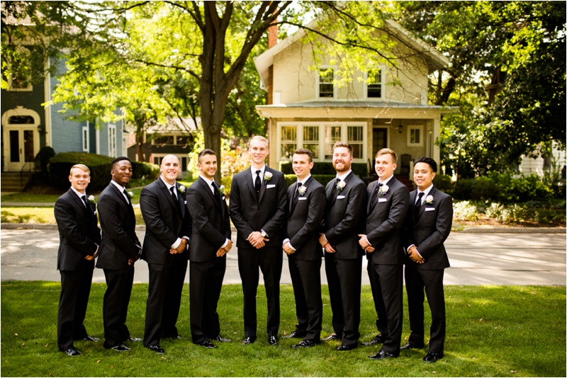 groomsmen and groom wearing black suits and black ties