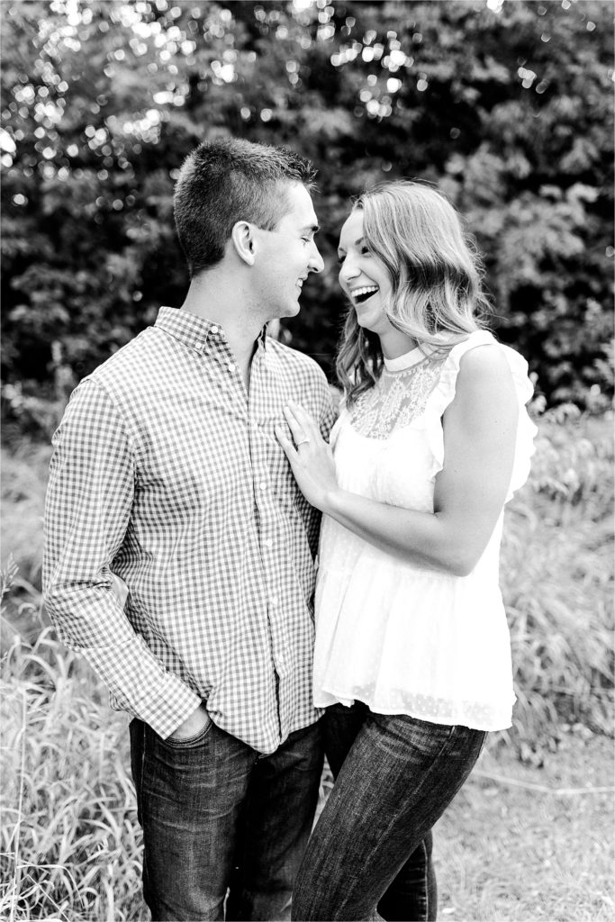 couple laughs during sunset engaement session at Comlara Park in Bloomington IL with Caitlin and Luke Photography