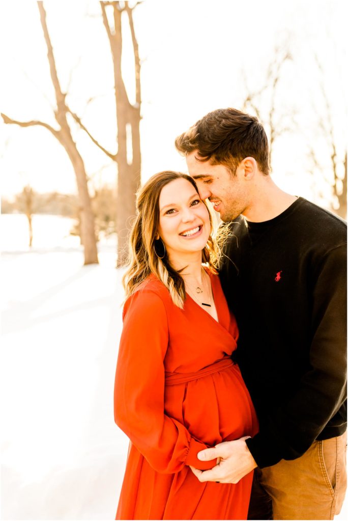 Bloomington Country Club maternity portraits with mother in red dress in the snow photographed by Illinois maternity photographers Caitlin and Luke Photography, IL maternity photographers