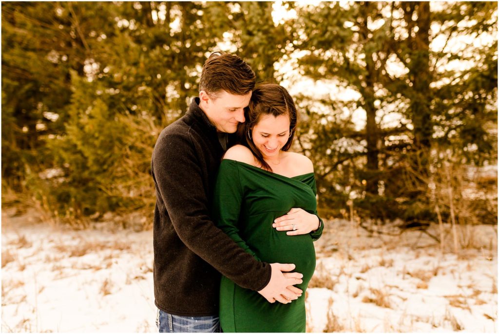 winter maternity session at Fransen Natural Area with mom in emerald green gown photographed by Normal Illinois maternity photographers Caitlin and Luke Photography